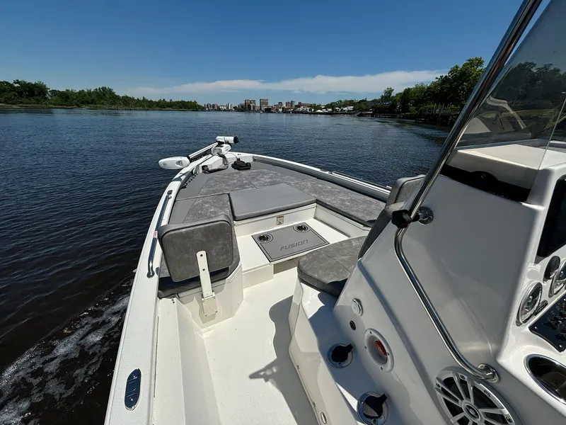 Slide: The Image of 2023 Avid 21 Fusion boat cruising on a calm river under a clear blue sky. - 5