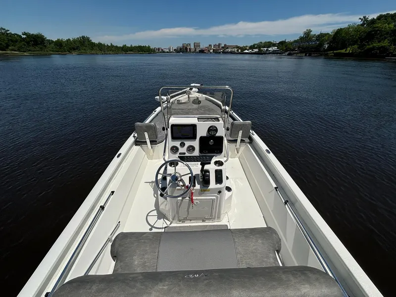 Slide: The Image of Avid 21 Fusion boat on calm river, 2023 model, clear sky, lush greenery. - 9