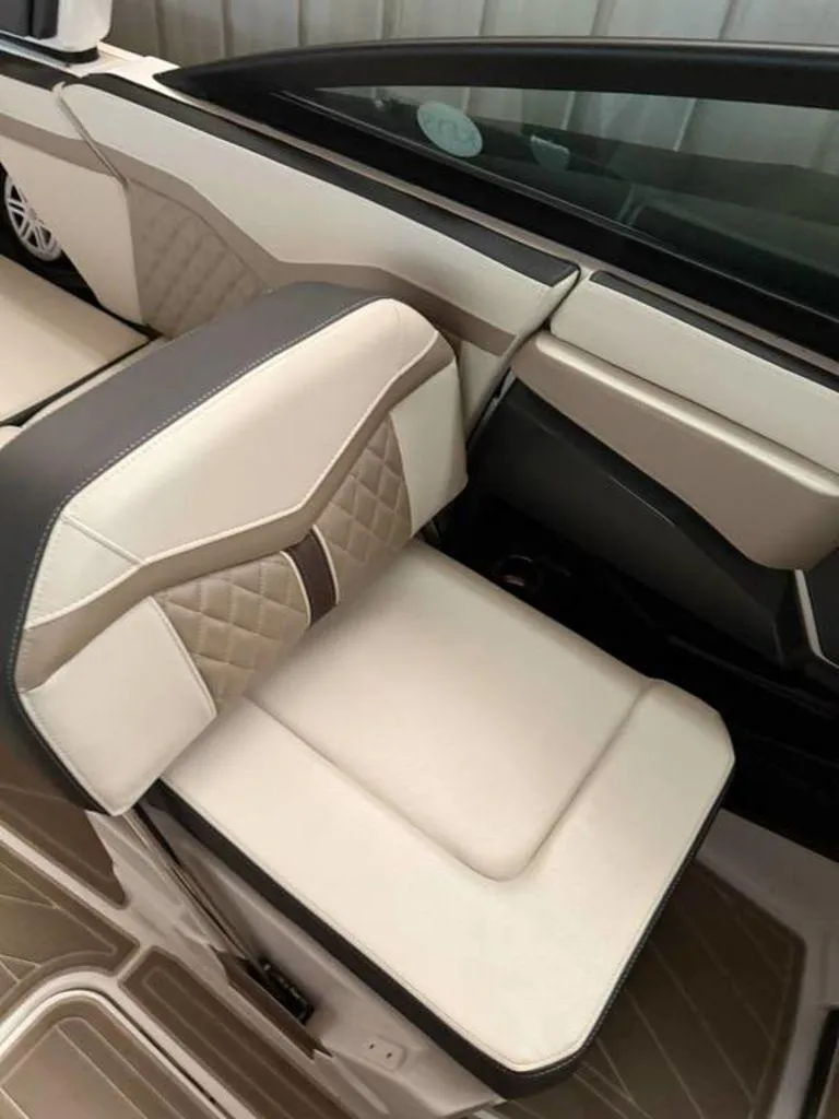 Slide: The Image of 2023 Monterey 258SS boat interior with beige and brown cushioned seating. - 4