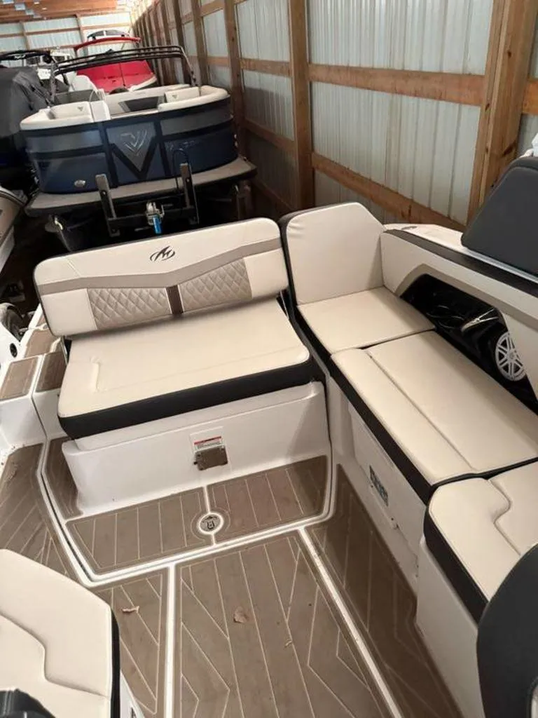 Slide: The Image of 2023 Monterey 258SS boat interior with beige seating and wood-patterned flooring. - 6