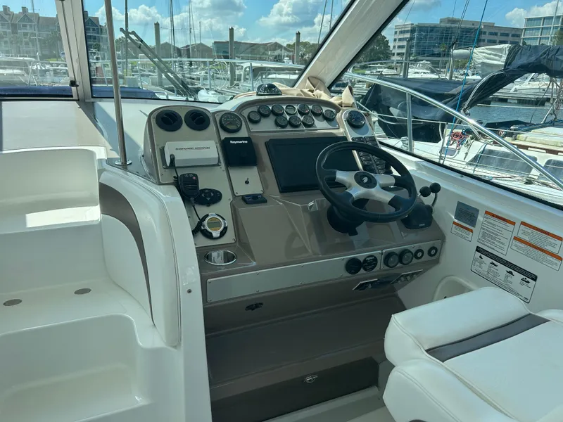 Slide: The Image of 2009 Cruisers Yachts 390 Sports Coupe helm with modern controls and marina view. - 16