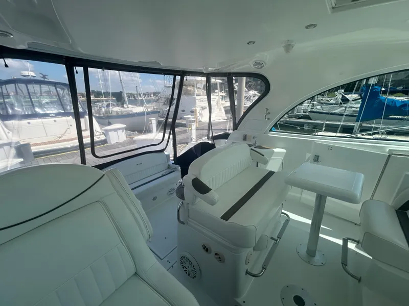 Slide: The Image of 2009 Cruisers Yachts 390 Sports Coupe interior with white seating and marina view. - 24