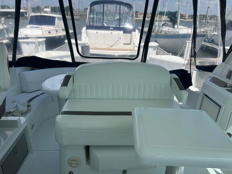 Slide: The Image of Interior view of 2009 Cruisers Yachts 390 Sports Coupe with white seating and marina backdrop. - 25