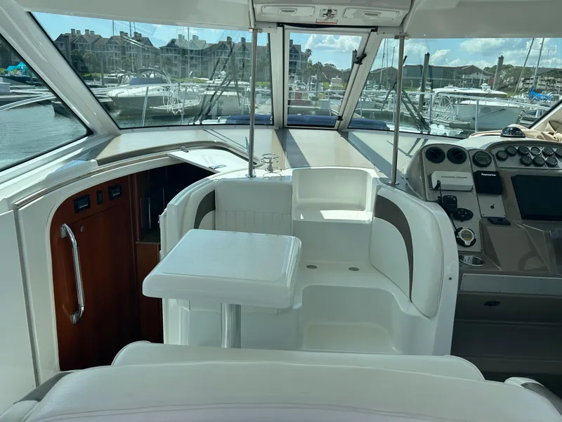 Slide: The Image of 2009 Cruisers Yachts 390 Sports Coupe interior with helm, seating, and marina view. - 26