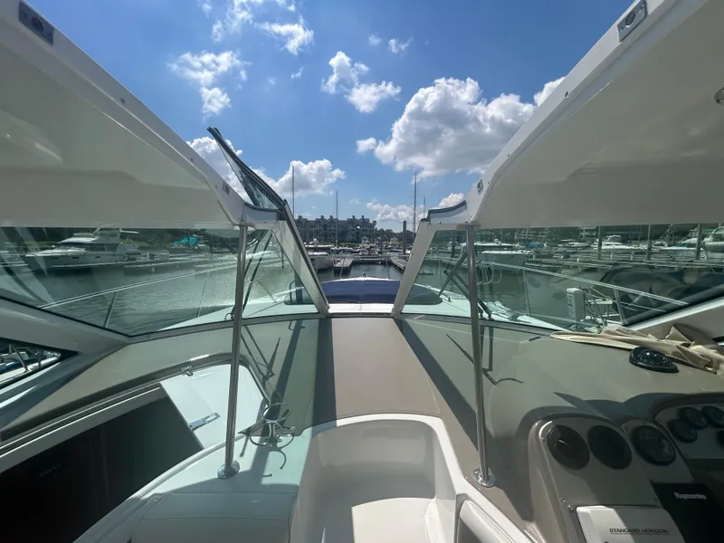 Slide: The Image of 2009 Cruisers Yachts 390 Sports Coupe cockpit view with marina backdrop under blue sky. - 32