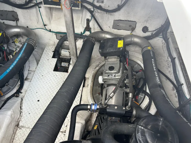 Slide: The Image of Engine compartment of 2009 Cruisers Yachts 390 Sports Coupe, showcasing mechanical components and hoses. - 48