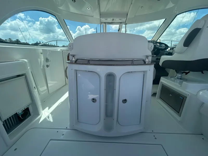 Slide: The Image of 2009 Cruisers Yachts 390 Sports Coupe interior with helm and seating under a clear sky. - 27