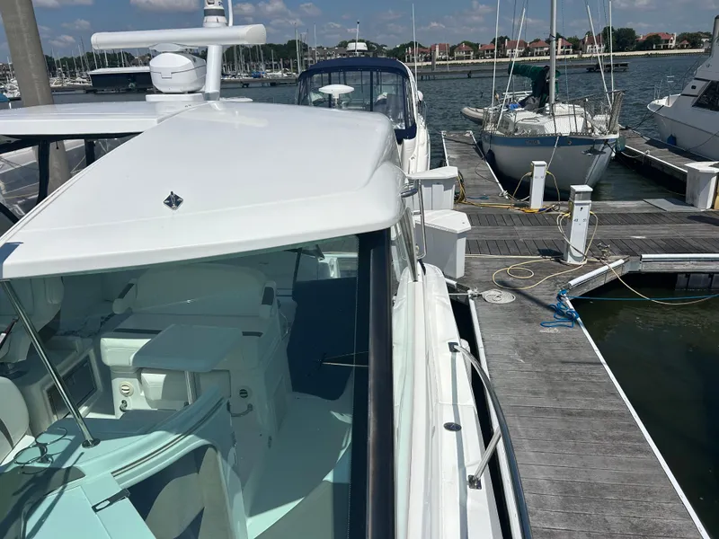 Slide: The Image of 2009 Cruisers Yachts 390 Sports Coupe docked at a marina with sailboats nearby. - 38