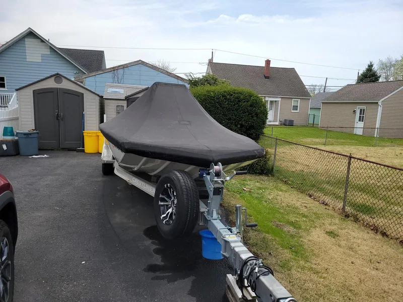 Slide: The Image of 2019 Crestliner 1800 Bay boat covered on trailer in residential driveway. - 3