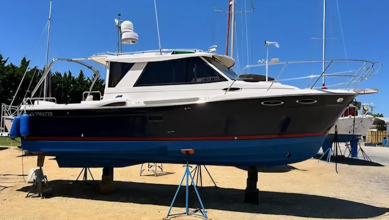 Slide: The Image of 2013 Cutwater C-28 boat on stands, blue hull, sunny day, marina background. - 1