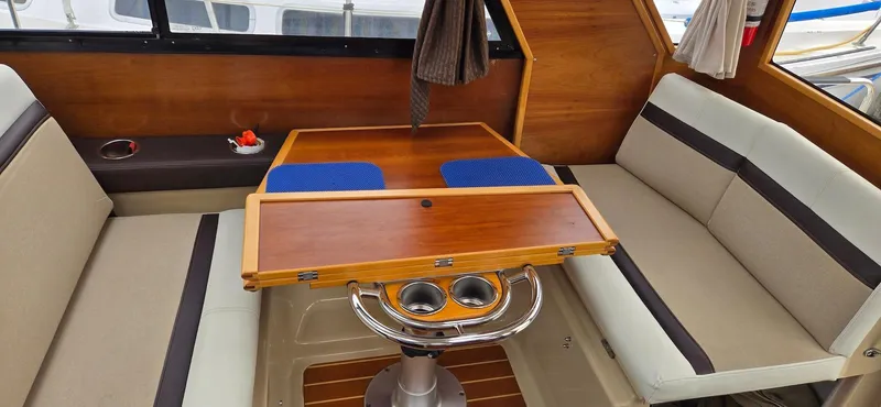 Slide: The Image of Interior of 2013 Cutwater C-28 boat with wooden table and cushioned seating. - 13