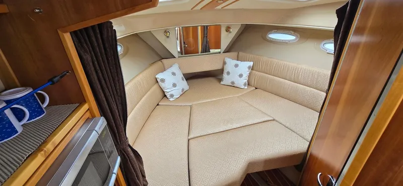 Slide: The Image of 2013 Cutwater C-28 cabin interior with cozy seating and nautical decor. - 20