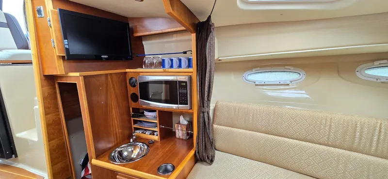 Slide: The Image of 2013 Cutwater C-28 interior with TV, microwave, and seating area. - 21