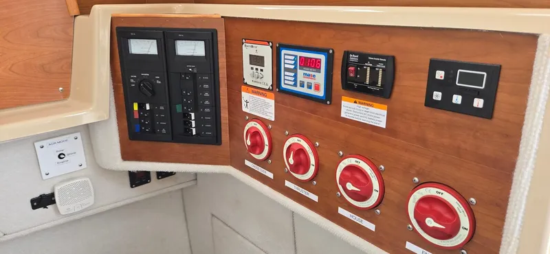 Slide: The Image of Control panel of a 2013 Cutwater C-28 boat with various switches and gauges. - 28