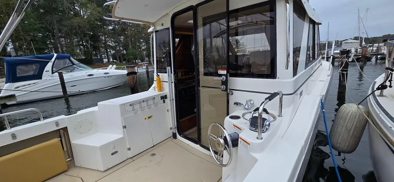 Slide: The Image of 2013 Cutwater C-28 boat docked, featuring spacious deck and modern design. - 4