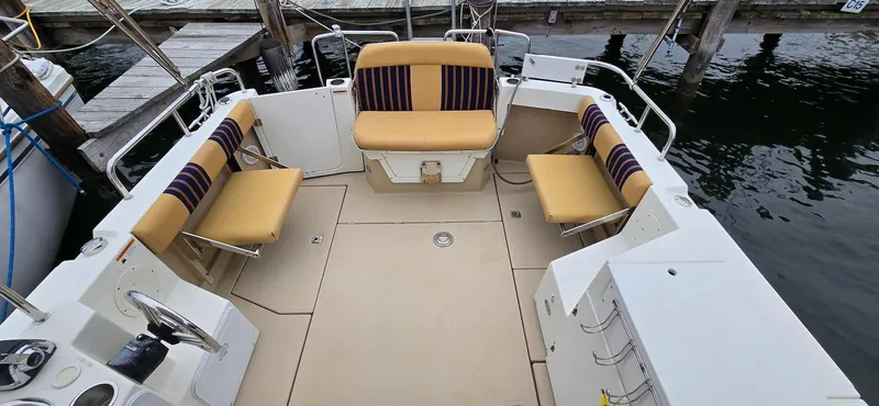 Slide: The Image of 2013 Cutwater C-28 boat deck with beige seating and striped cushions at a dock. - 6