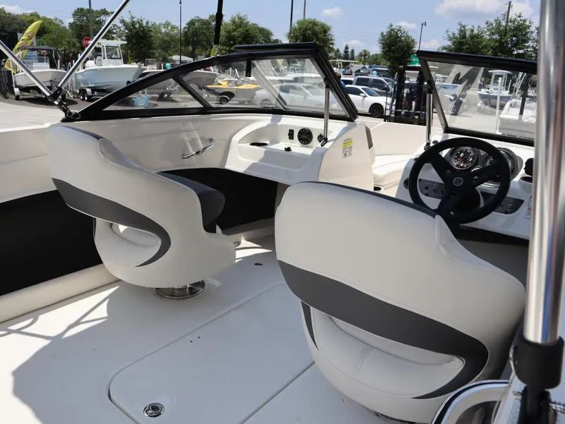 Slide: The Image of 2022 Bayliner 170 BR boat interior with modern seating and steering wheel. - 11