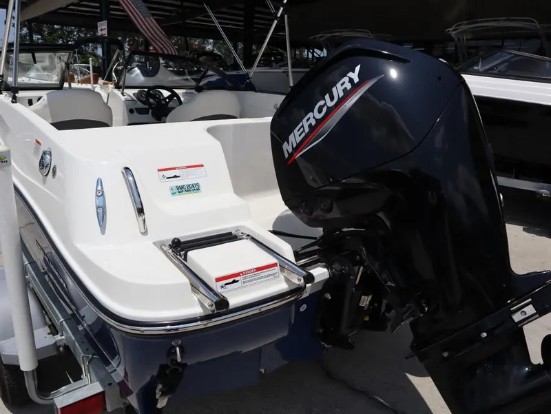 Slide: The Image of 2022 Bayliner 170 BR boat with Mercury outboard motor, displayed in a showroom. - 5