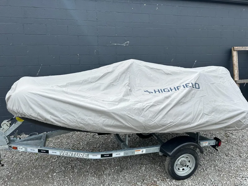 Slide: The Image of 2024 Highfield Classic 340 FCT boat covered on trailer, parked outdoors. - 15