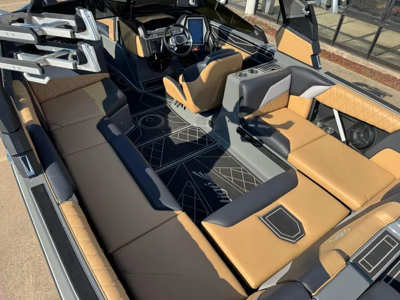 Slide: The Image of 2022 Tigé Z3 boat interior with tan and gray seating, modern dashboard, and spacious layout. - 10