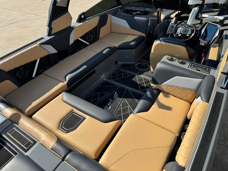 Slide: The Image of 2022 Tigé Z3 boat interior with luxurious tan and black seating, modern dashboard, and cup holders. - 11