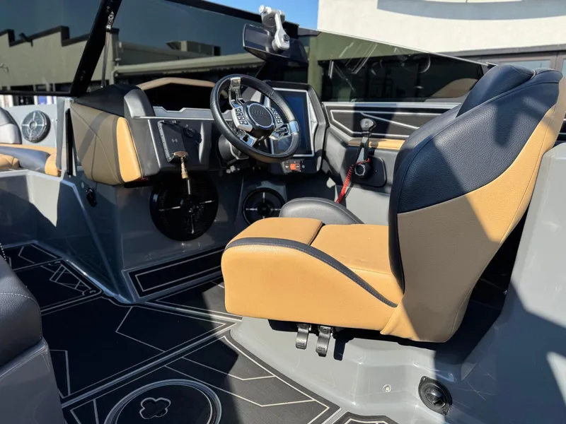 Slide: The Image of 2022 Tigé Z3 boat interior with tan and black seating, modern dashboard, and steering wheel. - 15