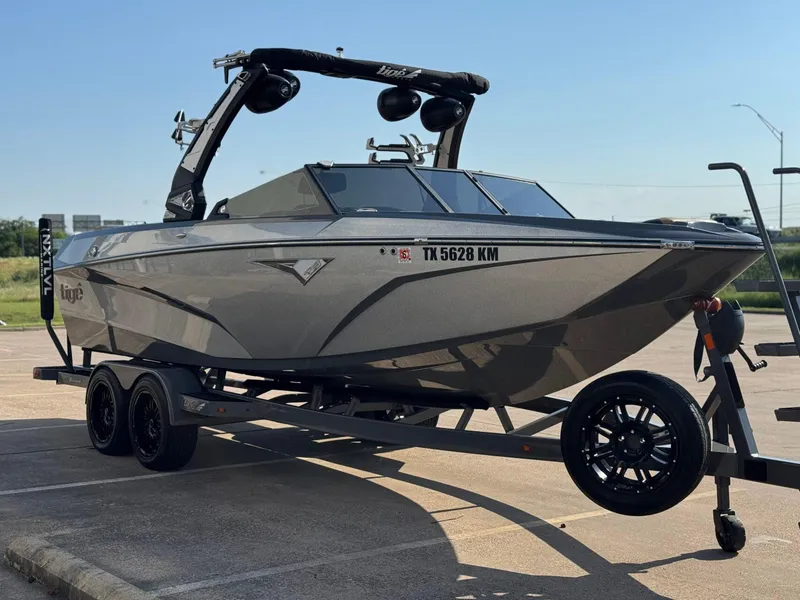 Slide: The Image of 2022 Tigé Z3 boat on trailer, parked in a lot under clear sky. - 5