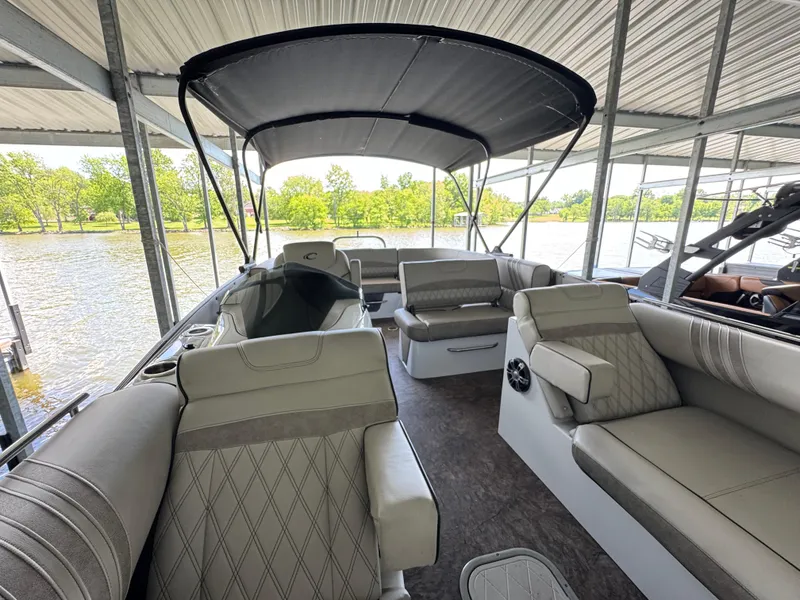 Slide: The Image of 2019 Crest Savannah 250 SLS pontoon boat with spacious seating under a covered dock. - 10