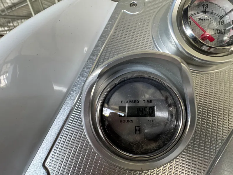 Slide: The Image of Hour meter and voltmeter on 2019 Crest Savannah 250 SLS boat dashboard. - 12