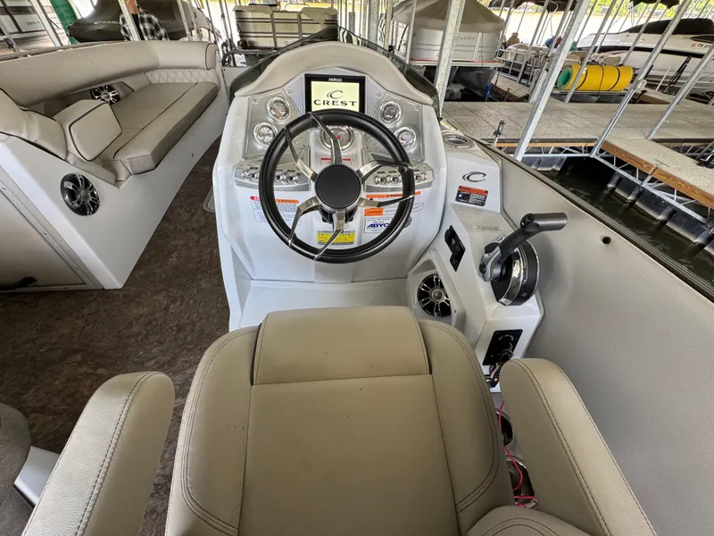 Slide: The Image of 2019 Crest Savannah 250 SLS boat interior with steering wheel and seating. - 13
