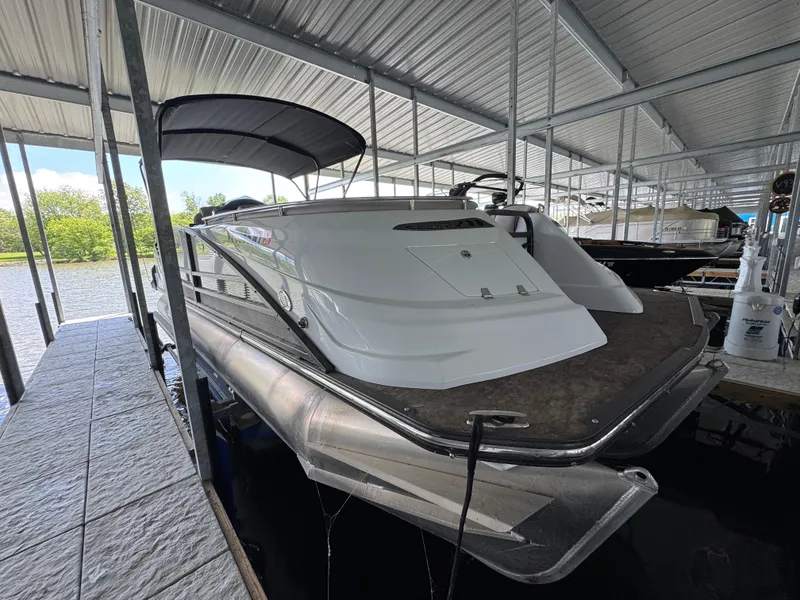 Slide: The Image of 2019 Crest Savannah 250 SLS pontoon boat docked under a covered marina. - 2