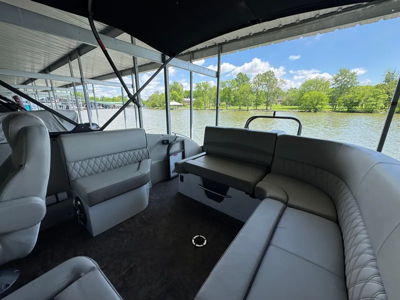 Slide: The Image of 2019 Crest Savannah 250 SLS pontoon boat interior with plush seating and scenic lake view. - 21