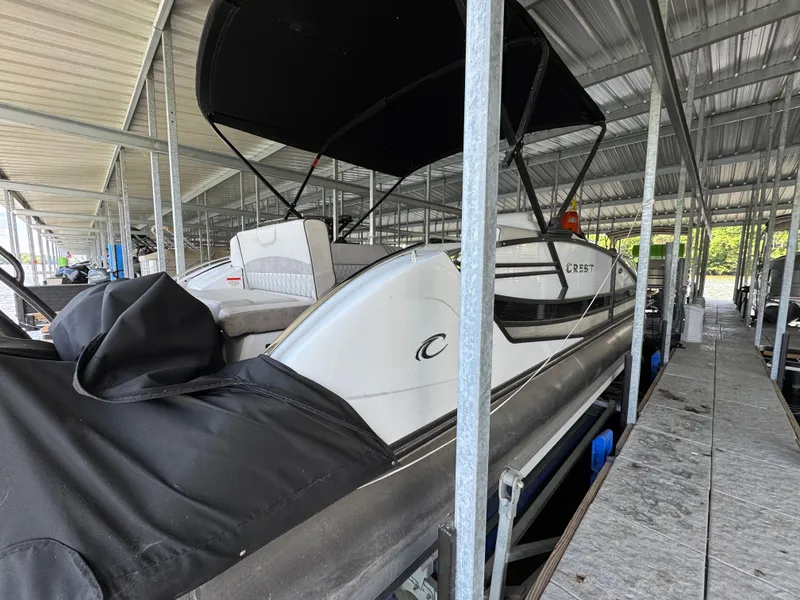 Slide: The Image of 2019 Crest Savannah 250 SLS pontoon boat docked under covered marina. - 24