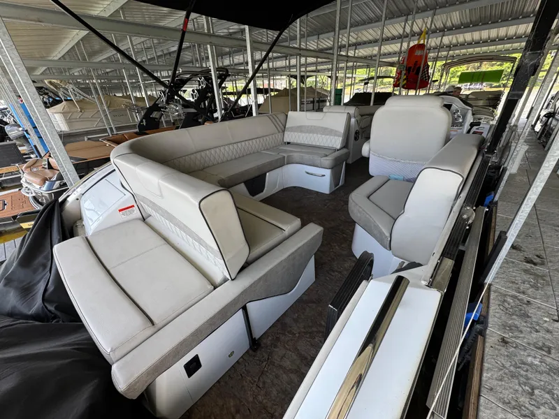Slide: The Image of 2019 Crest Savannah 250 SLS pontoon boat with spacious seating under a covered dock. - 25