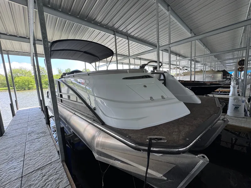 Slide: The Image of 2019 Crest Savannah 250 SLS pontoon boat docked under a covered marina. - 4
