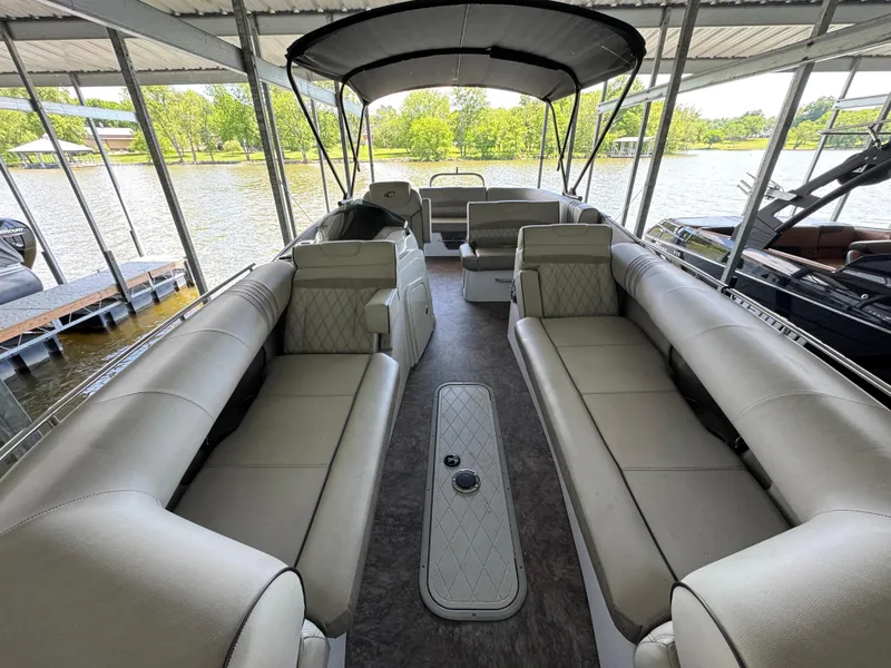 Slide: The Image of 2019 Crest Savannah 250 SLS pontoon boat with spacious seating, docked under a canopy. - 8