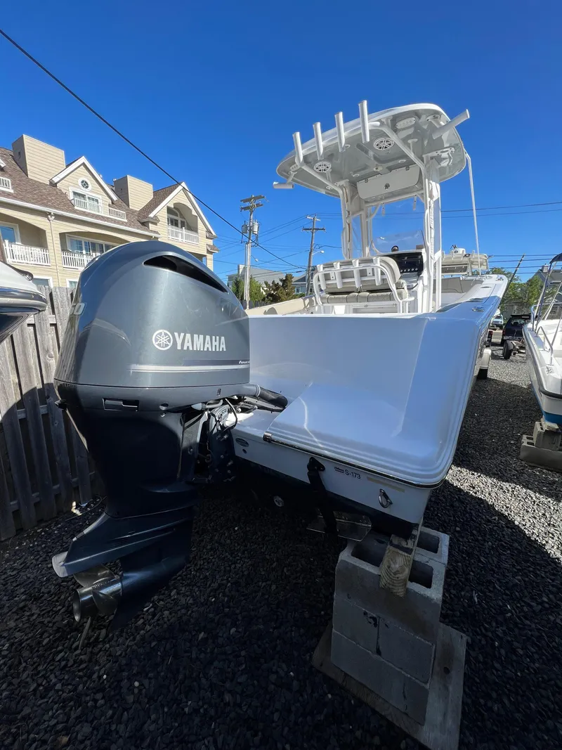 Slide: The Image of 2021 Sportsman Heritage 231 Center Console boat with Yamaha engine, parked on gravel. - 24