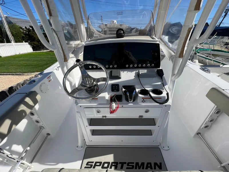Slide: The Image of 2021 Sportsman Heritage 231 Center Console boat cockpit with steering wheel and control panel. - 32