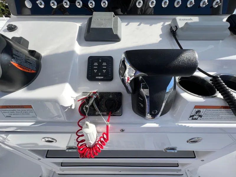 Slide: The Image of Control panel of 2021 Sportsman Heritage 231 Center Console boat with throttle and switches. - 34