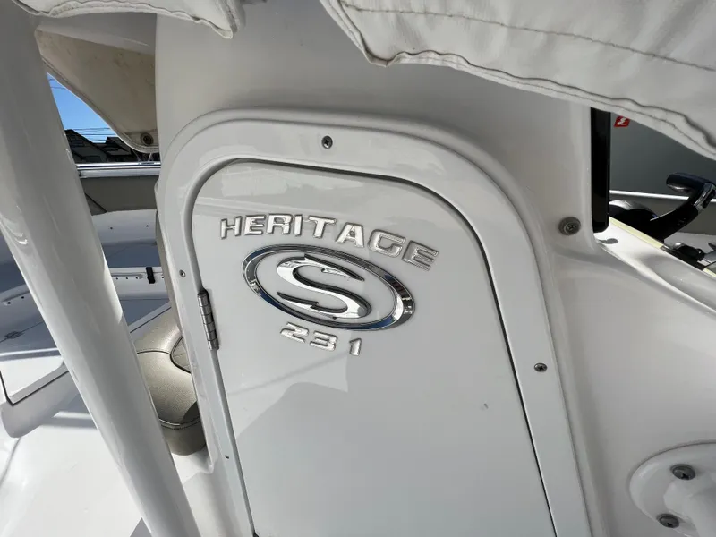 Slide: The Image of 2021 Sportsman Heritage 231 Center Console boat interior, featuring logo and storage compartment. - 44