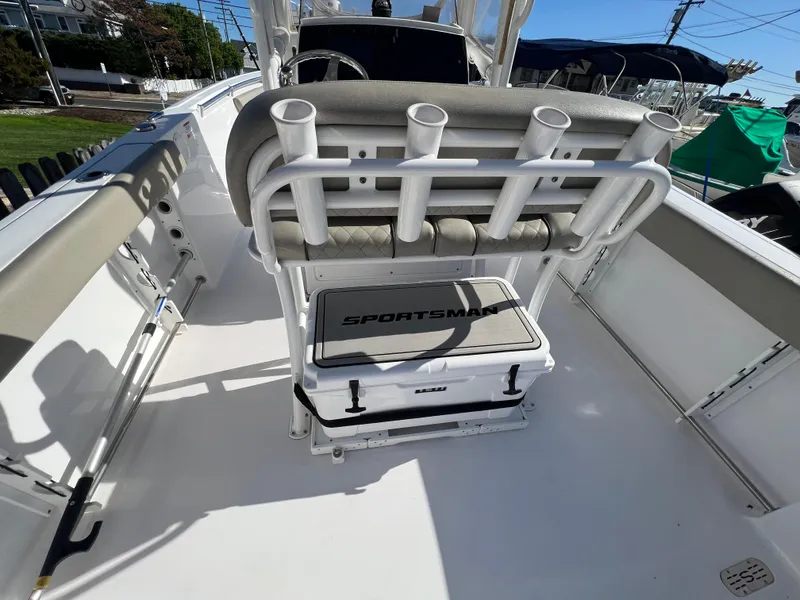Slide: The Image of 2021 Sportsman Heritage 231 Center Console boat interior with rod holders and cooler. - 45