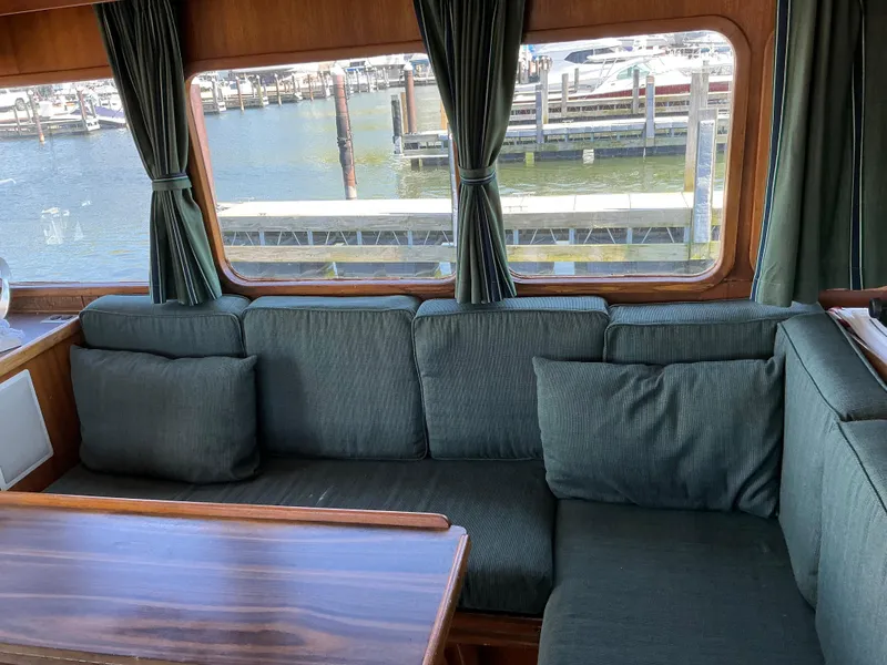 Slide: The Image of Interior of 1978 Californian 34 LRC yacht with green seating and marina view. - 11