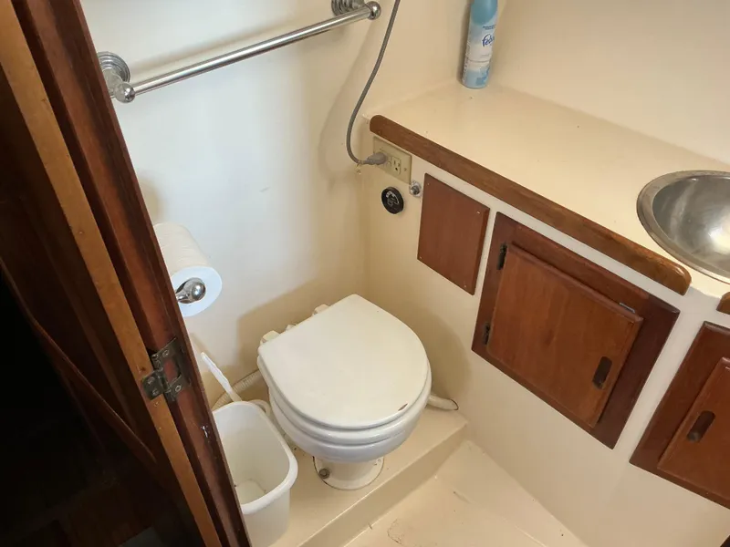 Slide: The Image of 1978 Californian 34 LRC boat bathroom with toilet, sink, and wooden cabinets. - 18