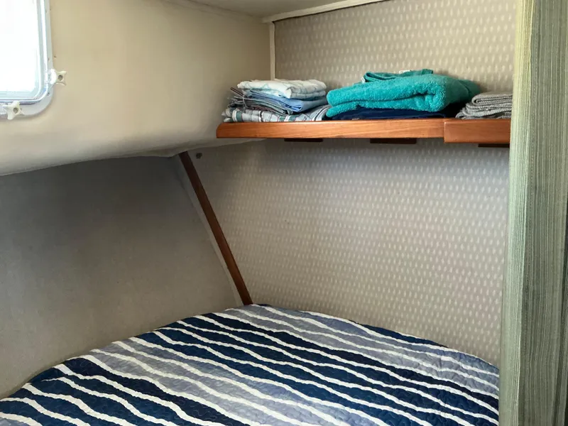 Slide: The Image of 1978 Californian 34 LRC cabin with striped bedding and neatly stacked towels on shelf. - 19