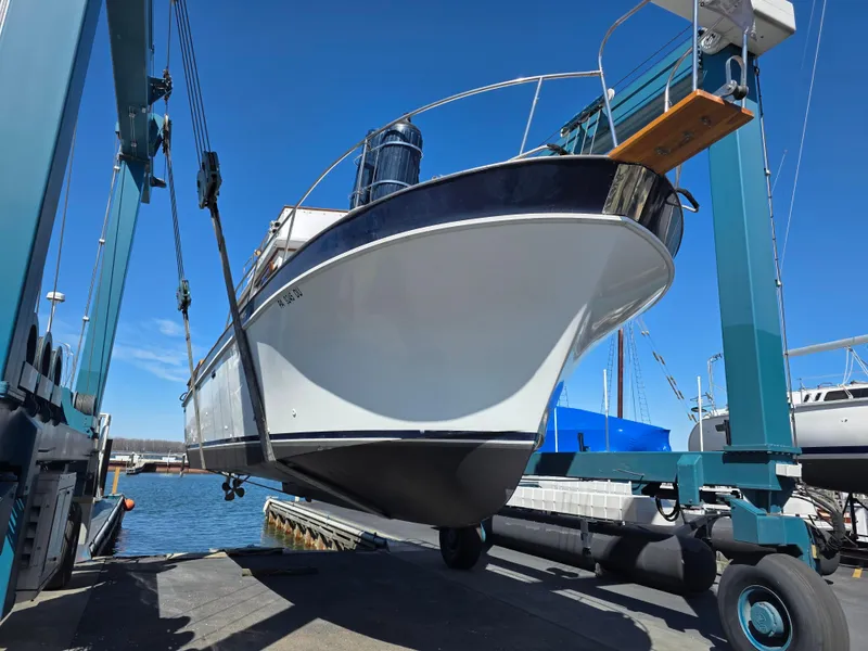 Slide: The Image of 1978 Californian 34 LRC boat being lifted at a marina with blue sky background. - 3