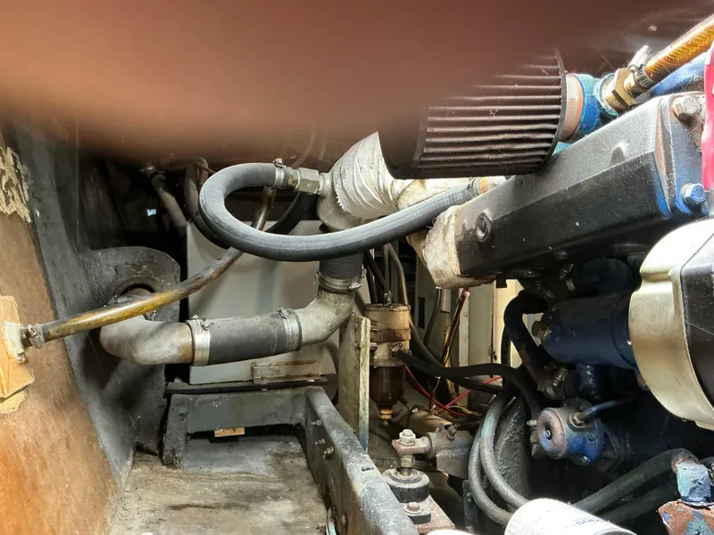 Slide: The Image of Engine compartment of a 1978 Californian 34 LRC boat, showcasing hoses and mechanical components. - 34