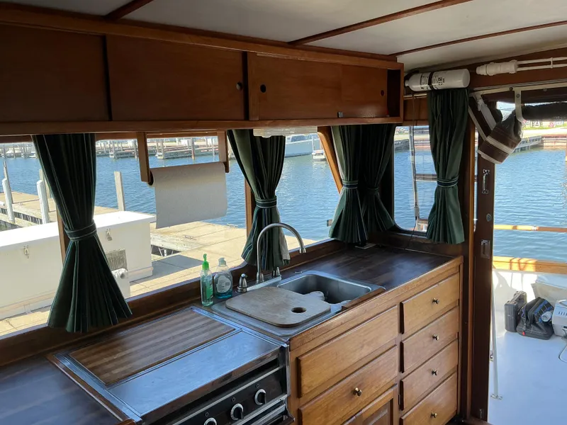 Slide: The Image of 1978 Californian 34 LRC boat kitchen with wooden cabinets and marina view. - 7