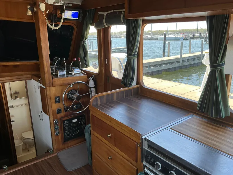 Slide: The Image of 1978 Californian 34 LRC boat interior with wooden helm, kitchen, and marina view. - 8