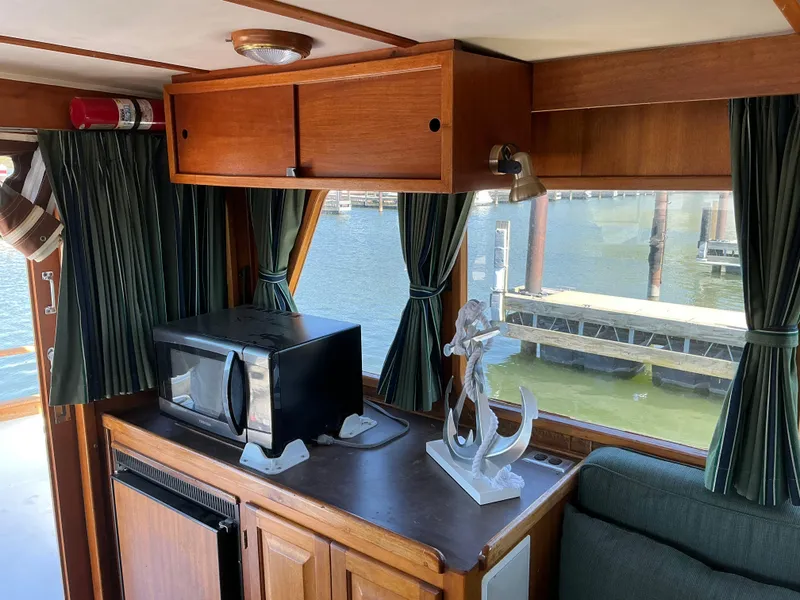 Slide: The Image of 1978 Californian 34 LRC interior with microwave, anchor decor, and marina view. - 9