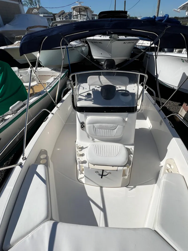 Slide: The Image of 2008 Boston Whaler 210 Dauntless boat with center console and seating, docked outdoors. - 16